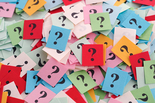 pile of colorful paper notes with question marks. close up.